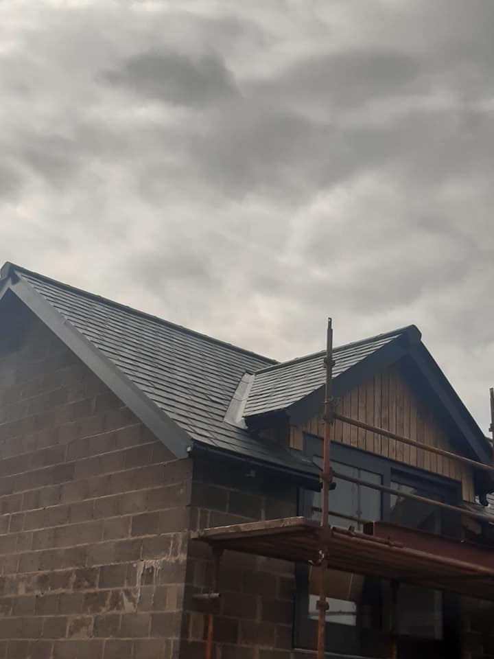 New slate roof with scaffolding on new build