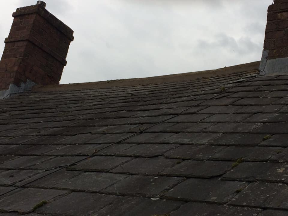Before: worn slate roof with chimneys